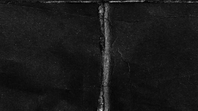Folded black paper animation. A dark, gritty stop-motion loop with a raw, mysterious, textured background.Dark grunge texture loop. A flickering animation of old