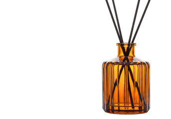 An amber glass reed diffuser bottle with black sticks, emitting fragrance, isolated on a transparent background