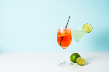 Margarita and Aperol Spritz at blue background.