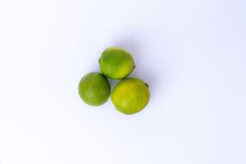 Whole lime fruit and slices isolated on white background. Fresh tropical citrus perfect for drinks, cooking, and food decoration.