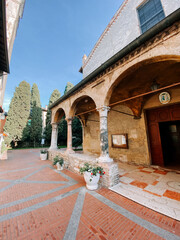 Historic courtyard with arches and greenery in warm afternoon light