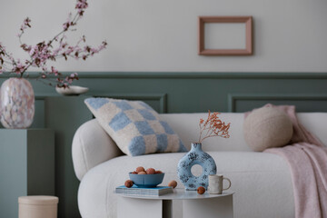 Warm and cozy composition of living room interior with boucle sofa, round coffee table, stylish...