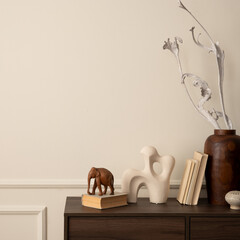 Minimalist composition of cozy living room interior with copy space, wooden sideboard, brown vase with dried flowers, modern sculpture, books and personal accessories. Homed decor. Template.