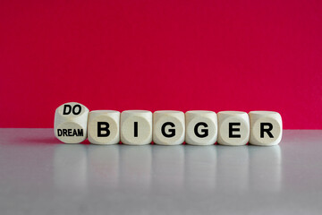 Dream and do bigger symbol. Turned a dice and changes words dream bigger to do bigger. Business and...