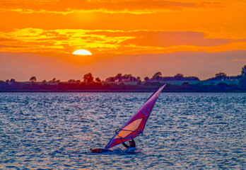 Surfer bei Sonnenuntergang  im Bodden von Wiek (Rügen), der ins Wasser gefallen ist