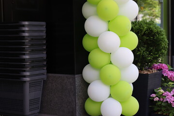 Balloon decoration in a vibrant green and white color scheme at a festive outdoor event space