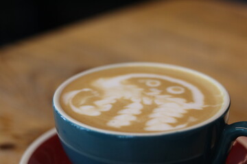 Unique latte art featuring a whimsical face design in a cafe on a cozy afternoon