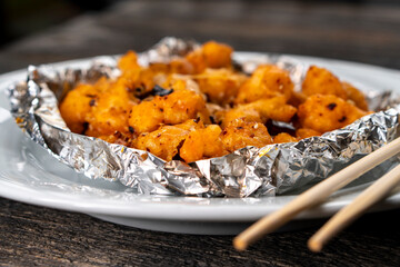 Crispy Shredded Chicken. Chinese Cuisine. A dish of meat. Appetizing chicken on a black background