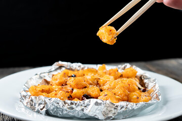 Crispy Shredded Chicken. Chinese Cuisine. A dish of meat. Appetizing chicken on a black background