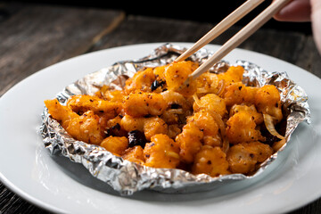 Crispy Shredded Chicken. Chinese Cuisine. A dish of meat. Appetizing chicken on a black background