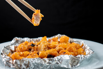 Crispy Shredded Chicken. Chinese Cuisine. A dish of meat. Appetizing chicken on a black background