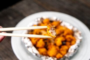 Crispy Shredded Chicken. Chinese Cuisine. A dish of meat. Appetizing chicken on a black background