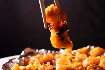 Crispy Shredded Chicken. Chinese Cuisine. A dish of meat. Appetizing chicken on a black background