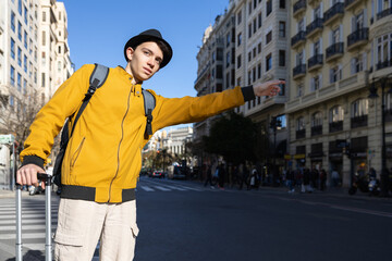 Man hailing a taxi with luggage, ready to head to his destination