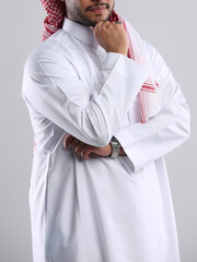 saudi arabian man in thob standing with hand to his chin side angel