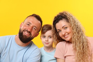 Portrait of happy family on yellow background