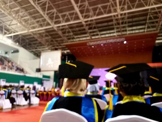 Students take part in the graduation procession wearing a toga in a blurry photo