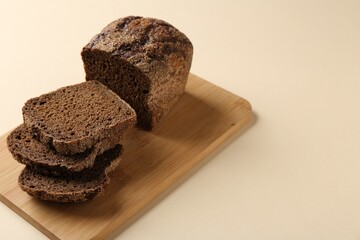 Pieces of fresh rye bread on beige background, closeup. Space for text