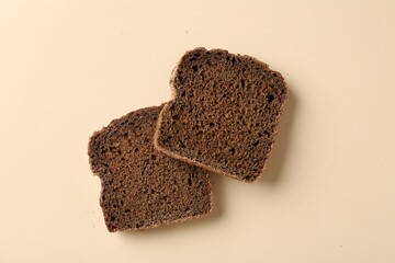Pieces of fresh rye bread on beige background, flat lay