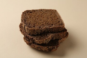 Pieces of fresh rye bread on beige background, closeup