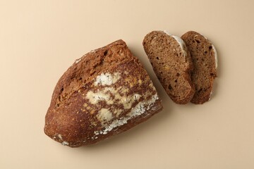 Pieces of fresh rye bread on beige background, flat lay