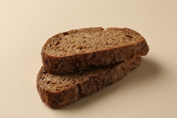 Pieces of fresh rye bread on beige background, closeup