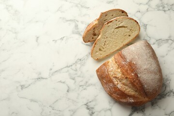 Pieces of fresh bread on white marble table, flat lay. Space for text