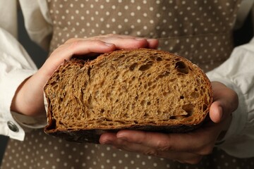 Woman with piece of fresh bread, closeup