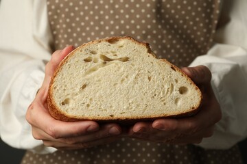 Woman with piece of fresh bread, closeup