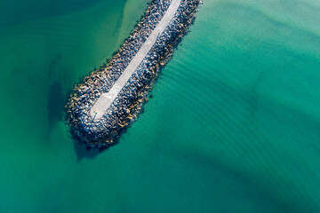 Aerial View of a Boat Entering a Stone Jetty Harbor Minimalist Aerial View of a Seawall, aerial...