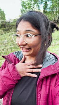 4k vertical selfie video of Indian young woman vlogging during trekking in mountains at Miyar Valley, Himachal Pradesh, India. Happy tourist hiking, sharing experience on social media. Travel blogger