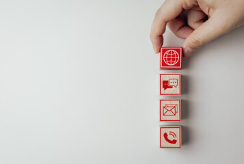 Wooden blocks with customer service  icon with online contact options for contact us or service department to solve problems and answer questions. Communication network system concept.