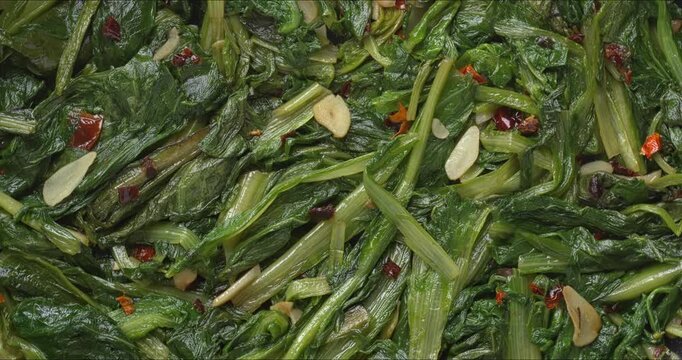 Background pattern of Roman Style Saut&eacute;ed Chicory greens (Cicoria Ripassata alla Romana). A delicious way to add green, leafy vegetables to meals. Table spin. 