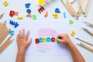 Children hands arranging colorful alphabet letters for learning activity