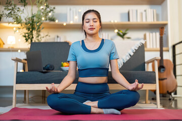 Mindfulness. Young woman meditating in a cozy home environment.