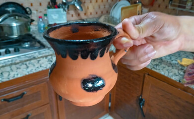 hand holding a clay cup