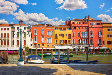 Venice, Italy. Antique italian houses on the channel with motorboats. Blue sky and white clouds. Sunny summer day. Popular touristic travel destination Europe.