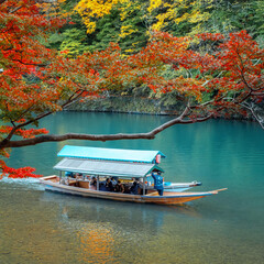 Fototapeta premium Kyoto, Japan - November 18 2024: Unidentified people ride the Hozu River Boat Cruises in Katsura river in Arashiyama district