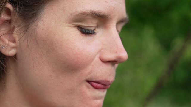 Woman eating herb, happy woman enjoying fresh green plant outdoors