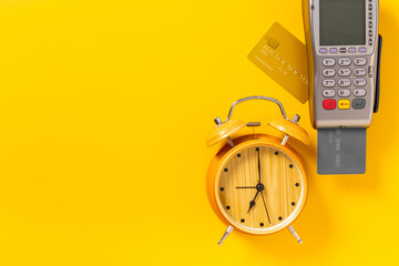 Obraz premium Pos payment terminal with bank card and alarm clock. Transaction speed. Time to pay concept