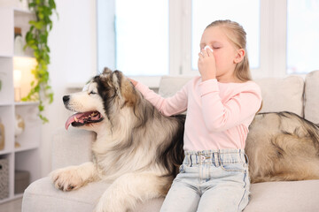 Girl suffering from allergy with her dog at home