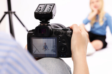 Photographer working with model in professional photo studio, selective focus © New Africa