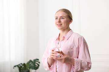 Young woman with glass of water at home
