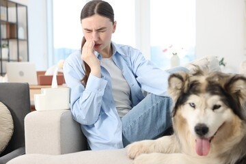 Woman suffering from allergy with her dog at home