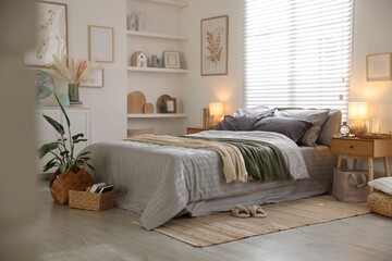 Comfortable bed with soft linens and blankets in room. Home textile