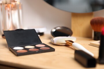 Different makeup products on wooden vanity indoors, closeup