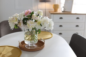 Beautiful table setting with vase of flowers in dining room, space for text