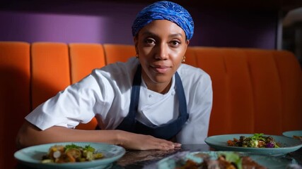 Culinary Professional in a Cozy Setting: A focused individual chef presents exquisite dishes, exuding confidence in a welcoming restaurant interior.