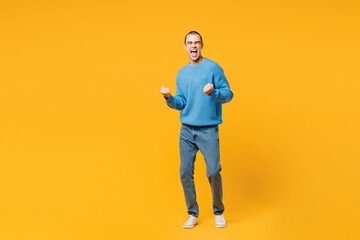 Full body young middle eastern man wearing blue sweatshirt casual clothes doing winner gesture...