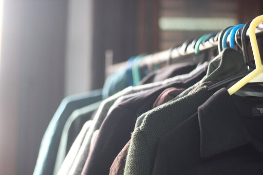 Roupas usadas, casacos e blusas em cabides na feira de moda circular.